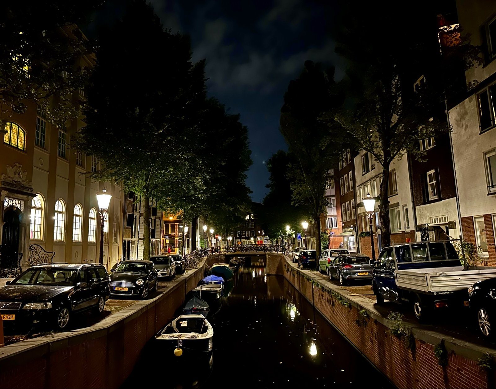 De Krom Boomssloot 's avonds met verlichte grachtenpanden en geparkeerde auto's